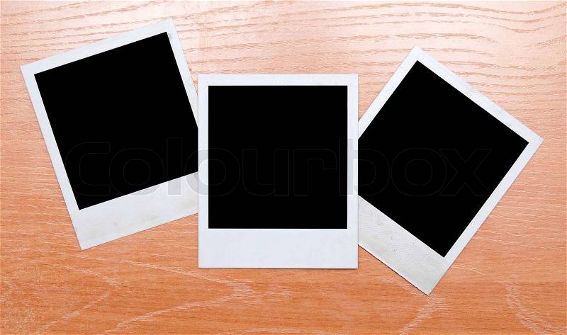Polaroids isolated on wooden background, stock photo
