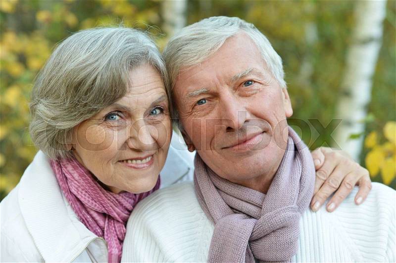 Happy senior couple in autumn park close-up, stock photo