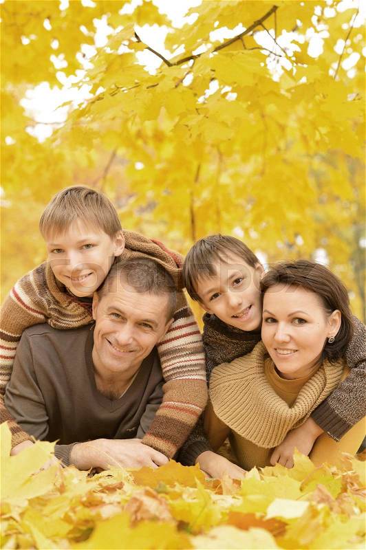 Portrait of happy family relaxing in autumn park, stock photo