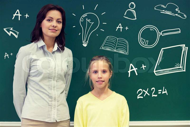 Education, elementary school, learning and people concept - little school girl and teacher at green chalkboard with doodles in classroom, stock photo