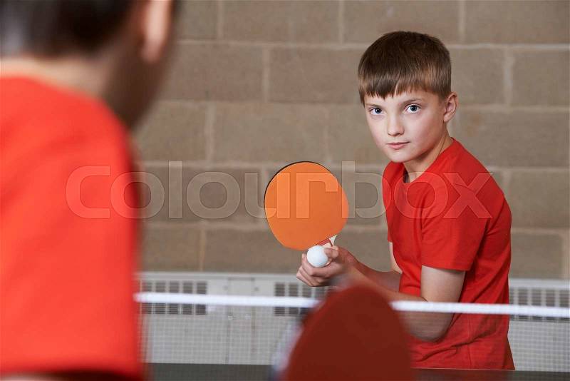 Two Boys Playing Table Tennis Match In School Gym, stock photo