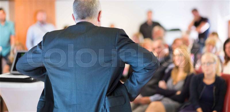 Business man leading a business workshop. Corporate executive delivering a presentation to his colleagues during meeting or in-house business training. Business and entrepreneurship concept, stock photo