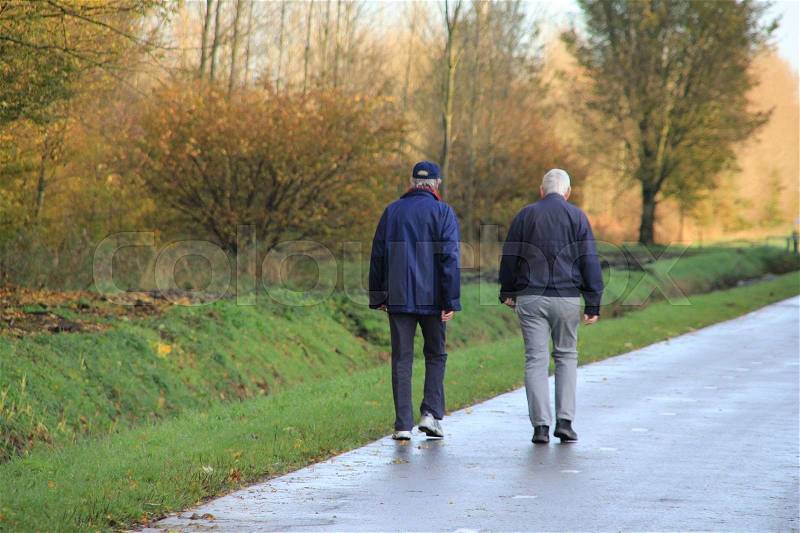 Couple, man and wife, walking at the cycle path at the countryside in fall, stock photo