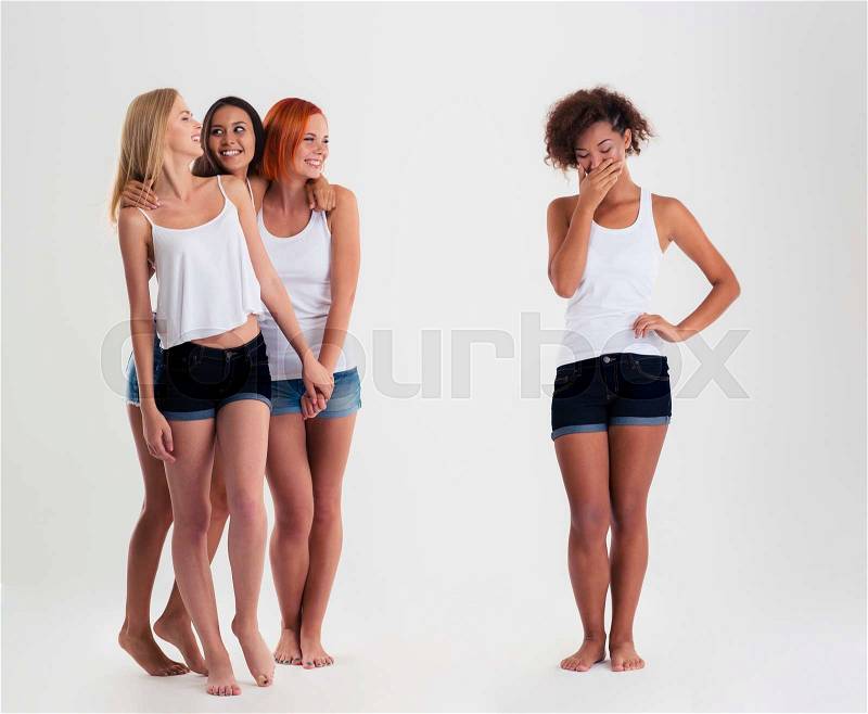 Upset afro american women standing while friends laughing with her isoalted on a white background, stock photo