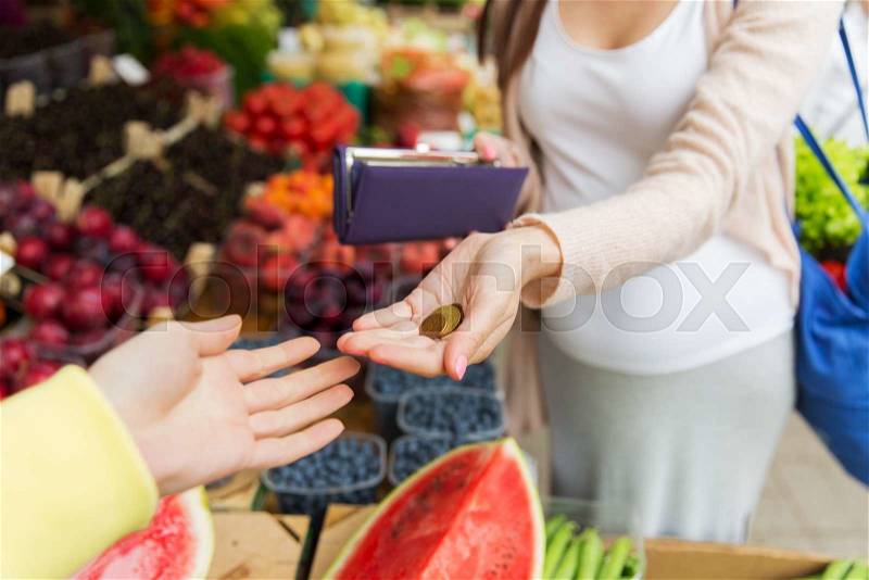 Sale, shopping, pregnancy and people concept - close up of pregnant woman with wallet and money buying food at street market, stock photo