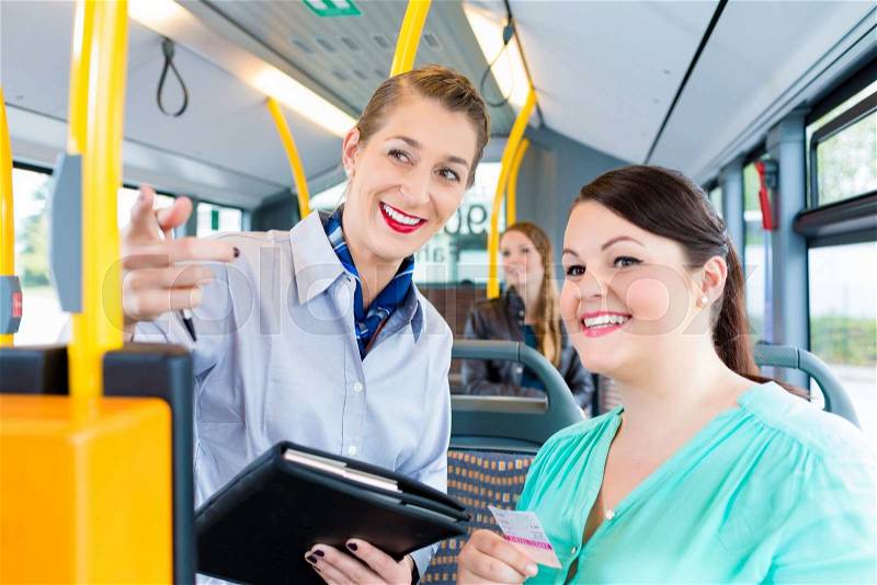 Inspector checking tickets in commuter bus, stock photo