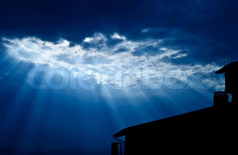 Light form the sky shining down on house / Crepuscular rays / Jesus light with house in deep blue sky, stock photo