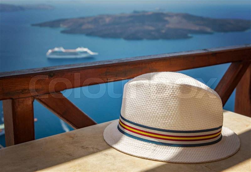 Image of a mans straw hat on a table. Santorini, Greece. , stock photo