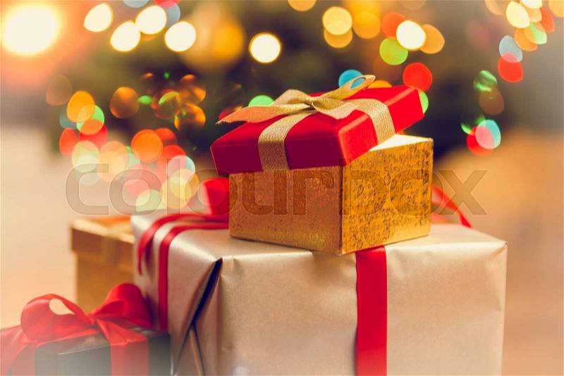 Toned photo of pile of gift boxes against Christmas lights, stock photo