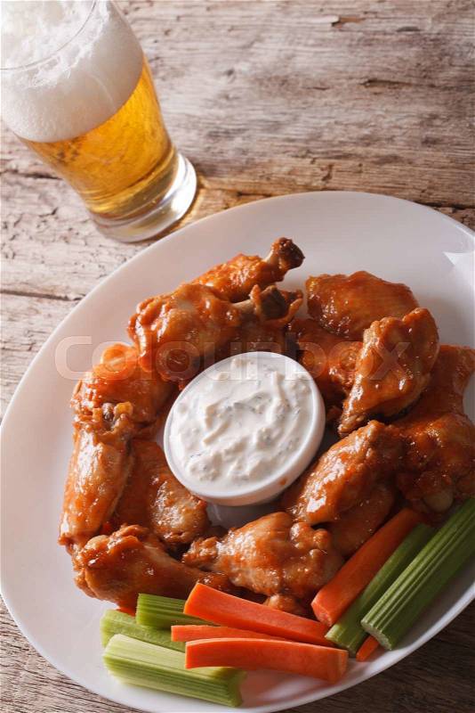 Buffalo hot wings with white sauce and beer on the table close-up vertical\, stock photo