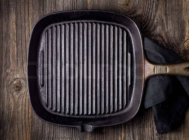 Empty black cooking pan on wooden table, top view, stock photo