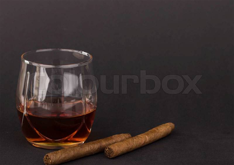 Whiskey and cigars. Located on a black background, stock photo