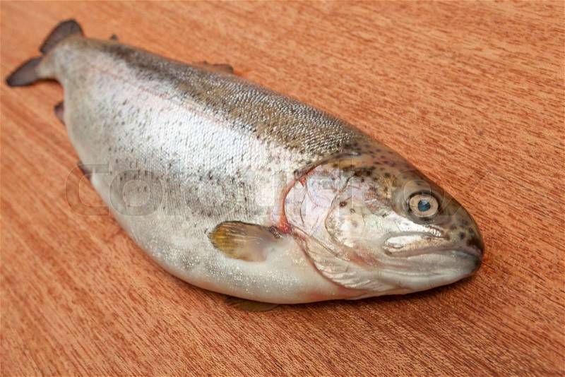 Rainbow trout on brown wooden surface. Shallow depth of field, stock photo