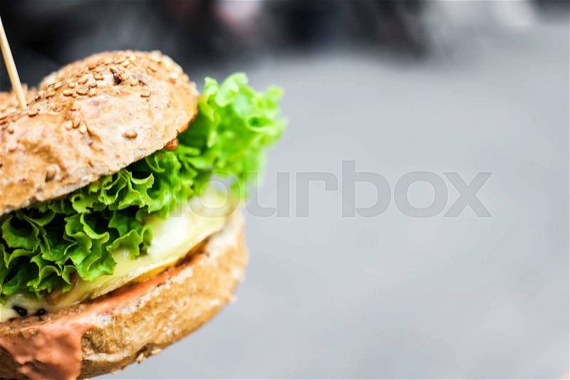 Fried burger with lettuce on grey background, stock photo
