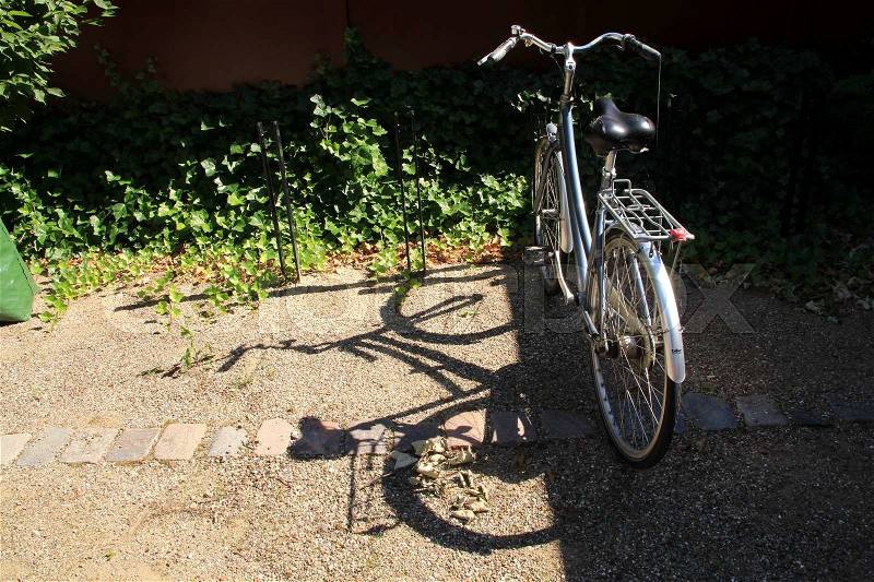 Sun and shadow of the bike at the parking place in the summer, stock photo