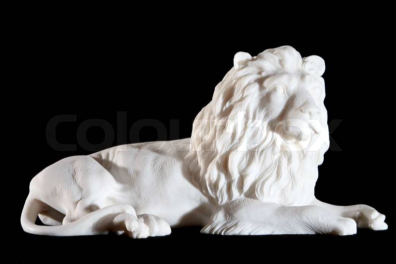 Classic white marble statuette of lying lion isolated on black background, stock photo