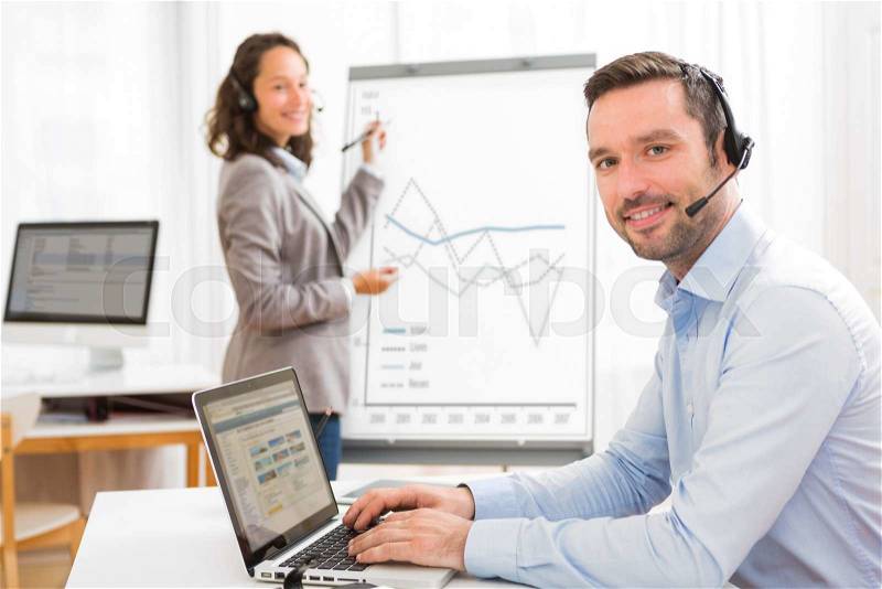 View of a Business man and woman analysing stats while doing video conference, stock photo