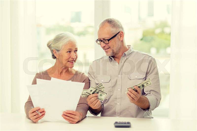 Family, savings, age and people concept - smiling senior couple with papers, money and calculator at home, stock photo