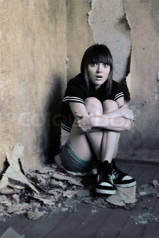 Scared young girl in a dirty place, corrupted makeup, stock photo