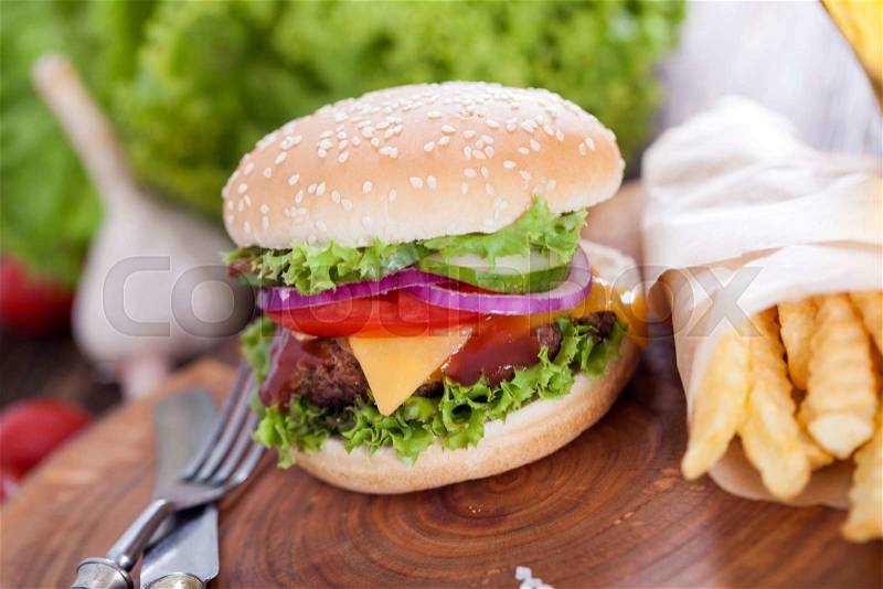 Beef burgers on a wooden board with chips and aromatic spices. Studio Shot, stock photo