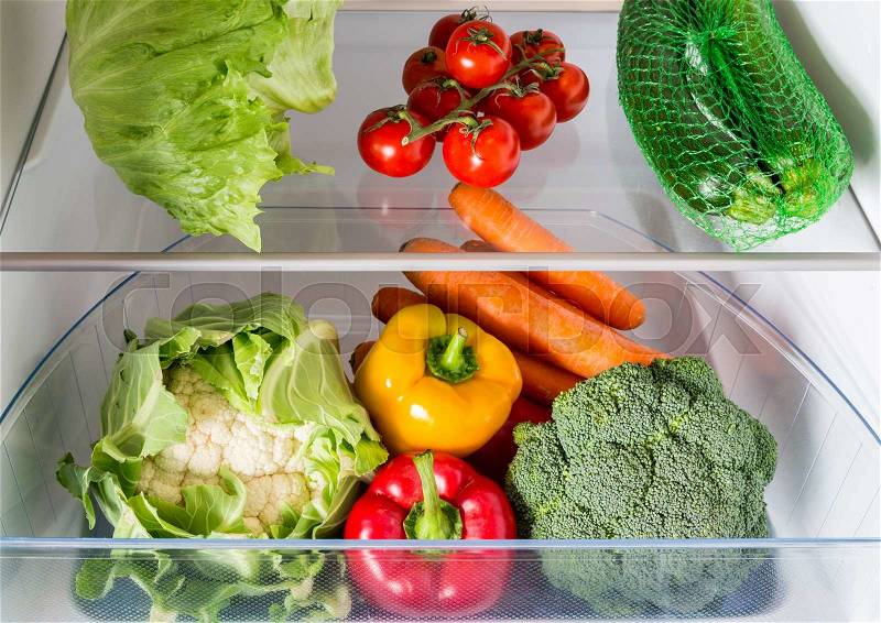 Open fridge filled with fruits and vegetables, stock photo