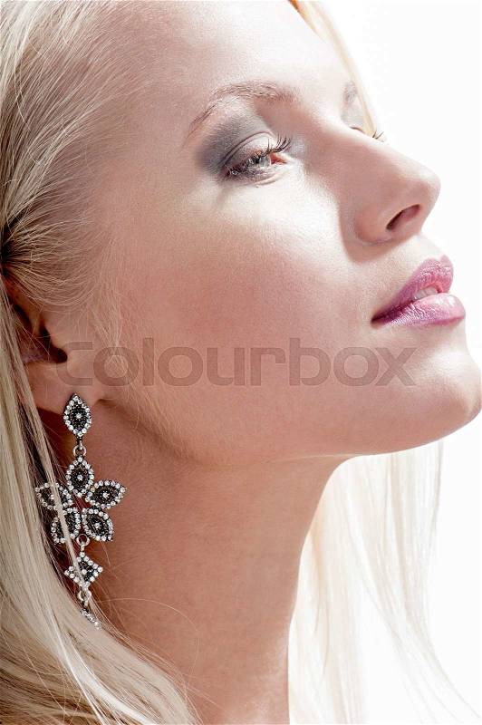 Portrait of beautiful blond woman wearing earrings with natural makeup posing on studio background.Perfect clean skin.Jewelry, stock photo