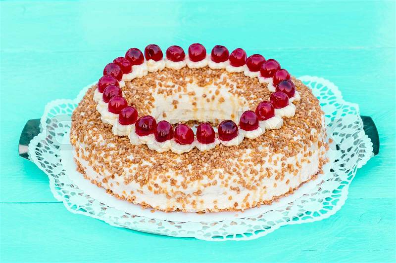 Frankfurt crown cake with cherries on a turquoise wood, stock photo