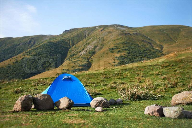 There ia a blue tent in the hills, stock photo