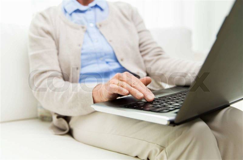 Technology, age and people concept - close up of senior woman with laptop computer at home, stock photo