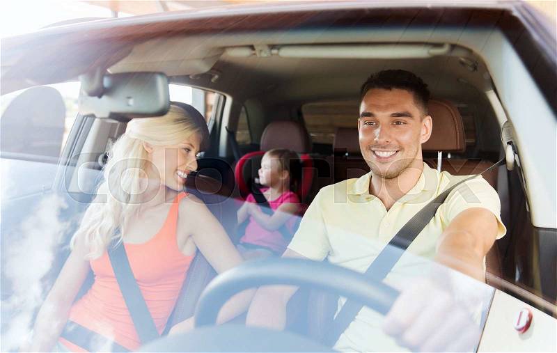 Family, transport, safety, road trip and people concept - happy man and woman with little child driving in car, stock photo
