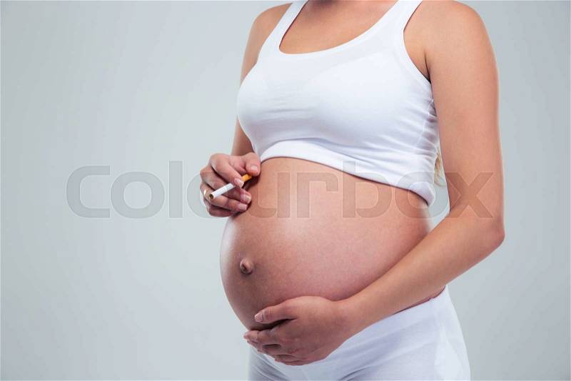 Closeup portrait of a pregnant woman smoking cigarette isolated on a white background, stock photo