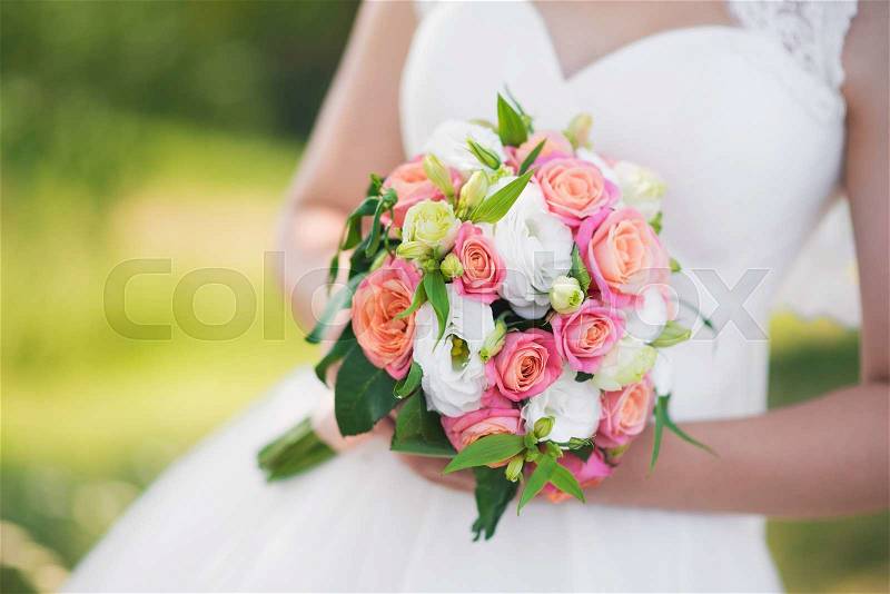 Closeup of wedding roses bouquet in woman hands, stock photo