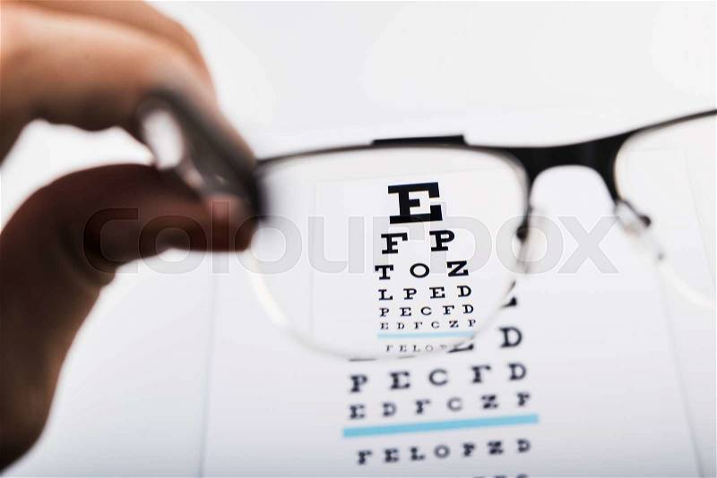 Woman looks at a chart test of eye glasses, stock photo