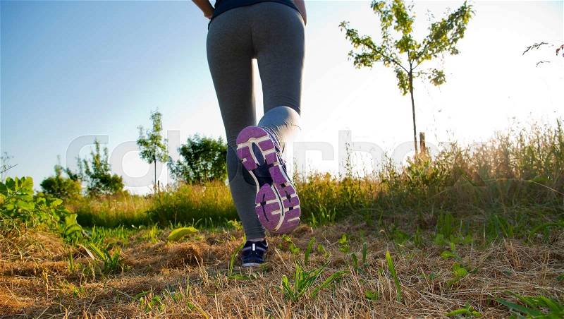 Fitness Girl running in a field with colorful outfit, stock photo