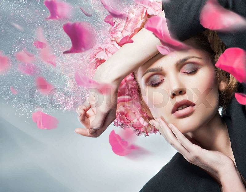 Close up portrait of art color woman face wearing black jacket and flying with wind pink flower petals.Perfect clean skin.Fashion look, stock photo