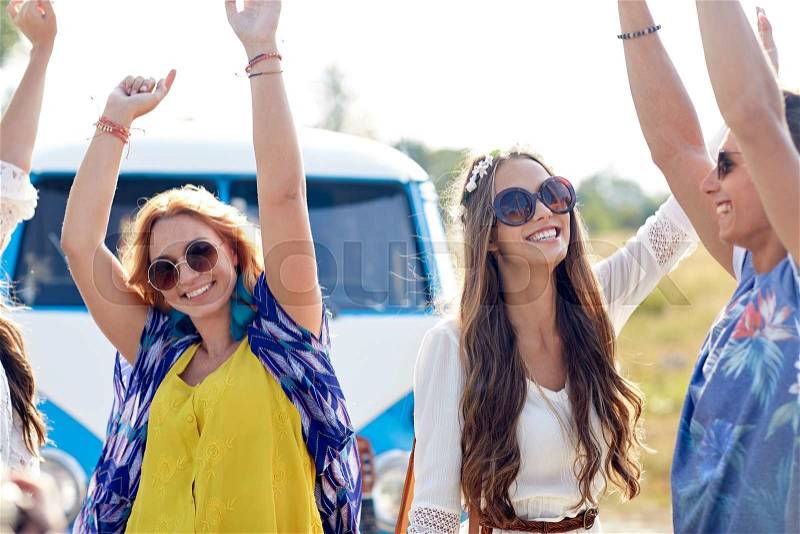 Nature, summer, youth culture and people concept - happy young hippie friends dancing over minivan car outdoors, stock photo