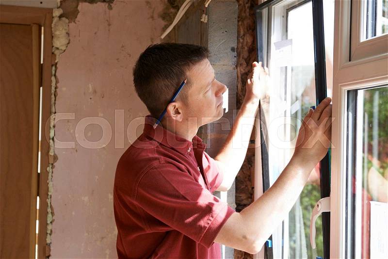 Construction Worker Installing New Windows In House, stock photo