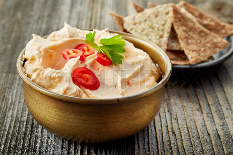 Bowl of cream cheese with chili and tomato, dip sauce on wooden table, stock photo