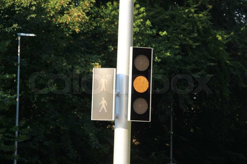 Traffic light is orange for the cars and red for the pedestrians at the intersection in the village Kolding in Denmark, stock photo