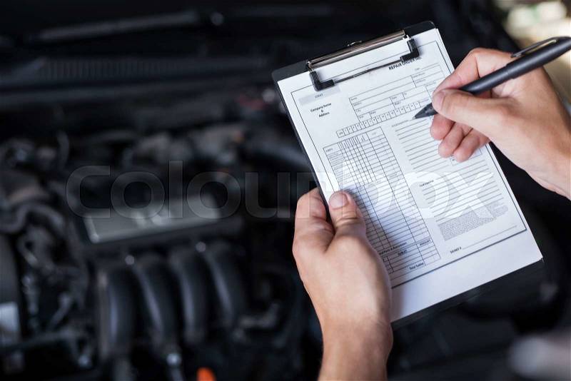 Mechanic repairman inspecting car closeup, stock photo