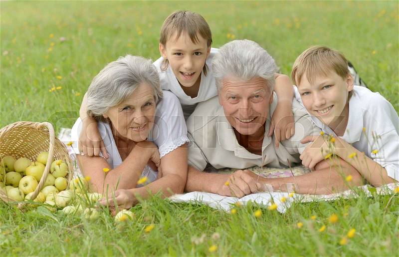 Happy cute smiling family on green summer grass, stock photo