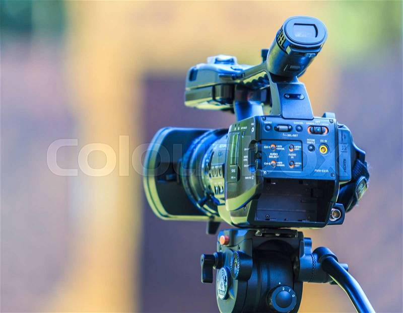 Video camera operator working with his professional equipment, stock photo