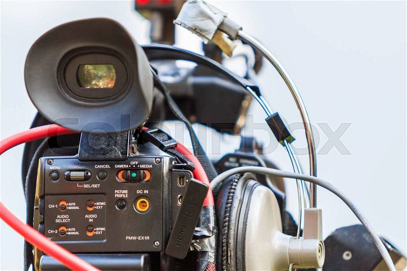 Video camera operator working with his professional equipment, stock photo