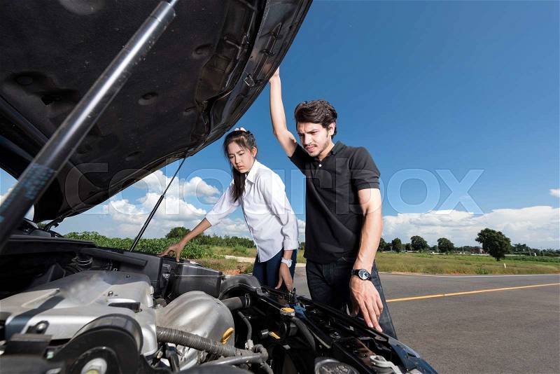 Man and woman stand by the broken car and don\'t know what to do, stock photo