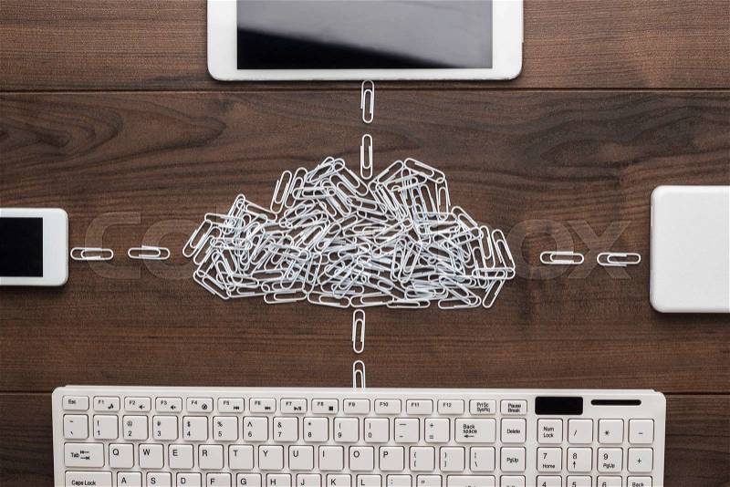 Cloud service concept: computer, tablet, phone, hard drive connected to the cloud made of white paper clips, stock photo