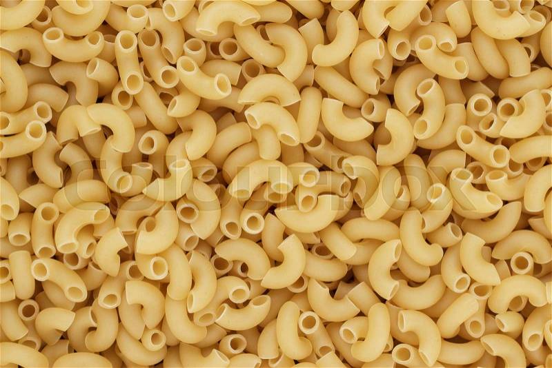 Close-up of dry uncooked macaroni pasta on the table , stock photo