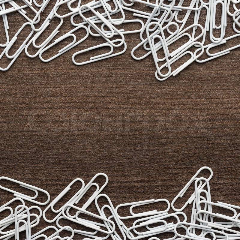 White paper clips on the wooden table with copy space, stock photo