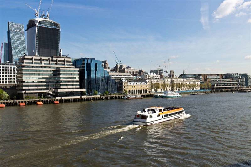 A water taxi transports people along the River Thames in London, England, stock photo
