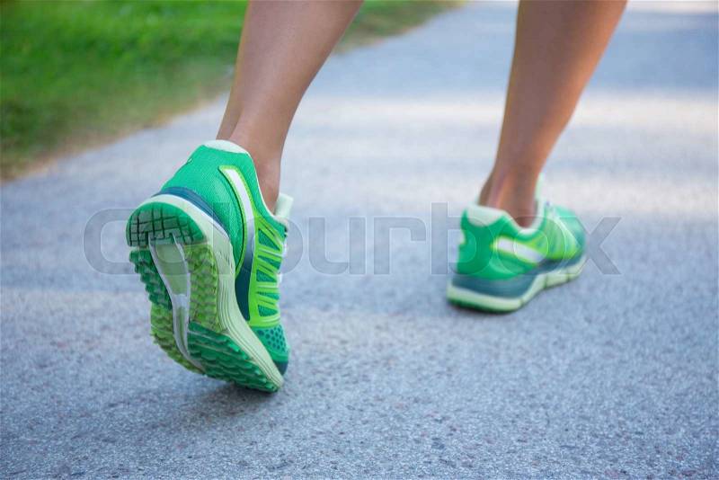 Close up of jogging woman in green running shoes, stock photo