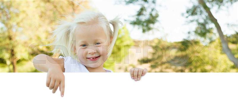 Cute Little Girl Outside Holding Edge of White Board with Room For Text, stock photo